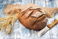 Rye bread lies on the burlap and a knife next to it.