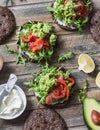 Rye bread sandwich with cream cheese, smoked salmon, arugula, mashed avocado on rustic wooden background, top view. Healthy delici Royalty Free Stock Photo