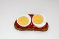 Rye bread sandwich with two halves of boiled egg with tomato sauce on white background Royalty Free Stock Photo