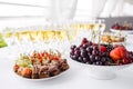 Rye bread sandwiches, canapes, bruschetta on white plate. solemn banquet. Lot of glasses champagne or wine on the table Royalty Free Stock Photo
