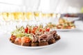 Rye bread sandwiches, canapes, bruschetta on white plate. solemn banquet. Lot of glasses champagne or wine on the table Royalty Free Stock Photo