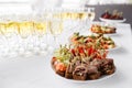 Rye bread sandwiches, canapes, bruschetta on white plate. solemn banquet. Lot of glasses champagne or wine on the table Royalty Free Stock Photo