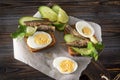 bread sandwiches with sprats, fresh cucumber, herbs and boiled egg on a dark wooden background, canned fish