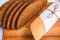 Rye bread slices and Fresh Homemade Sliced French Baguette Bread on the wooden board in the white background Royalty Free Stock Photo