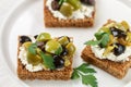 Rye bread toast canape with black and green olives, feta chees