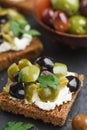 Rye bread toast canape with kalamata, black and green olives, feta chees