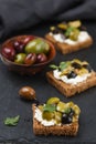 Rye bread toast canape with kalamata, black and green olives, feta chees
