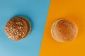 Rye and classic bun empty isolated. American food classic rye round burger bread isolated on blue and orange background. Two Royalty Free Stock Photo