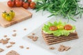 Rye crispy bread Swedish crackers with soft cheese, lettuce leave, cherry tomatoes and rosemary on white background