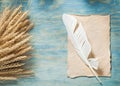 Rye ears vintage paper sheet feather on wooden board