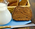 Rye homemade bread with milk and a knife on a board Royalty Free Stock Photo