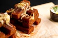 Rye roasted toasted toasts with cheese, folded well, served on parchment beech on a wooden cutting board.