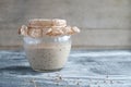 Rye sourdough on whole grain flour in glass jar on table, yeast-free leaven starter for healthy organic rustic bread Royalty Free Stock Photo