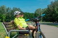 Rzeszow, Poland - Jun 23.2019 A young guy and a young girl are resting after a bike ride, drinking water, sitting on a bench. Royalty Free Stock Photo