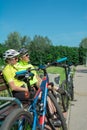 Rzeszow, Poland - Jun 23.2019 A young guy and a young girl are resting after a bike ride, drinking water, sitting on a bench. Royalty Free Stock Photo