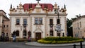 A beautiful old theater building in a European city. In the foreground is a roundabout