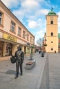 Rzeszow, Poland, November 2017: The musician is walking with a guitar in his hands along the street, a monument