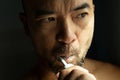 40s adult beard Asia man portrait cleaning teeth by electric toothbrush with morning light from window