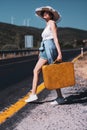 20s age One woman with a straw hat hitchhiking by the country roadside Royalty Free Stock Photo