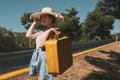 20s age One woman with a straw hat hitchhiking by the country roadside Royalty Free Stock Photo