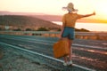 20s age One woman with a straw hat hitchhiking by the country roadside Royalty Free Stock Photo