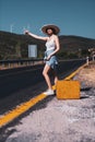 20s age One woman with a straw hat hitchhiking by the country roadside Royalty Free Stock Photo