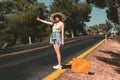 20s age One woman with a straw hat hitchhiking by the country roadside Royalty Free Stock Photo