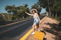 20s age One woman with a straw hat hitchhiking by the country roadside Royalty Free Stock Photo