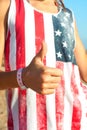 It`s alright! Young girl in american shirt showing thumb up.