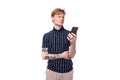25s blond man dressed in a T-shirt with tattoos sits on the phone