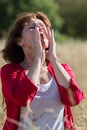 50s brunette woman having pollen allergies outdoors Royalty Free Stock Photo