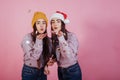 It`s Christmas time. Confetti and good mood for all. Air kisses. Two sisters twins standing and posing in the studio Royalty Free Stock Photo