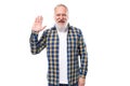 50s elderly gray-haired man with beard greets showing palm on white background