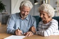 60s elderly spouses at lawyer office sign marriage contract