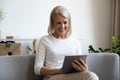 Elderly woman holding tablet funny spending free time watching comedy Royalty Free Stock Photo