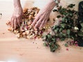 70 s elegant old senior lady working manually with sick wrinkled hands curing dried roses for home decoration hobby Royalty Free Stock Photo