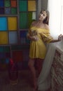 1960`s female flower child poses in yellow dress - retro shoot