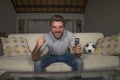30s or 40s football fan man watching soccer game celebrating his team scoring goal crazy happy screaming cheering his team sitting Royalty Free Stock Photo