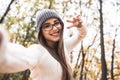 It`s good weather for photo shooting! Attractive girl is showing peace sign and smiling when making selfie Royalty Free Stock Photo