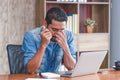 30s handsome businessman take a short note on paper while reading article from internet, and feeling tired from reading long time Royalty Free Stock Photo