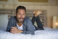 30s happy and handsome man at home in casual shirt and jeans lying on bed relaxed at home smiling confident and happy feeling Royalty Free Stock Photo