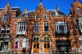 Front view typical dutch red brick gabled houses with shadows of bare trees against blue winter sky