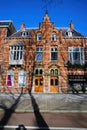 Front view  typical dutch red brick gabled houses with shadows of bare trees against blue winter sky Royalty Free Stock Photo