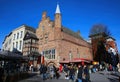 View over market square with restaurants on historic red brick house with VVV tourist information against blue winter sky