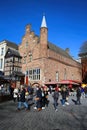 View over market square with restaurants on historic red brick house with VVV tourist information against blue winter sky