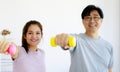 50s man and woman Asian family exercise and workout together with happy and relaxed smile faces. Two elderly couple holding small