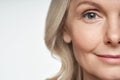 50s mid aged woman looking at camera. Anti age skin care. Half face crop Royalty Free Stock Photo