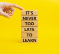 Its Never to Late to Learn symbol. Wooden blocks with words It is Never to Late to Learn. Beautiful yellow background. Businessm Royalty Free Stock Photo