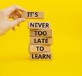Its Never to Late to Learn symbol. Wooden blocks with words Its Never to Late to Learn. Beautiful yellow background. Businessm Royalty Free Stock Photo