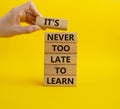 Its Never to Late to Learn symbol. Wooden blocks with words Its Never to Late to Learn. Beautiful yellow background. Businessm Royalty Free Stock Photo